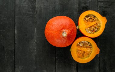 Siyah tahta masada kırmızı kuri ezmesi. Japon kabağı, turuncu Hokkaido kabağı ya da bebek kırmızı hubbard. Bir tam balkabağı ve iki dilim, kopyalanmış düz bileşim..