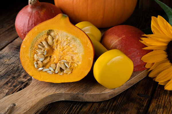 Dumbbell with Hokkaido pumpkins. Healthy fitness lifestyle autumn or fall rustic composition for Halloween or Thanksgiving. Gym workout and sport training concept on wooden background.