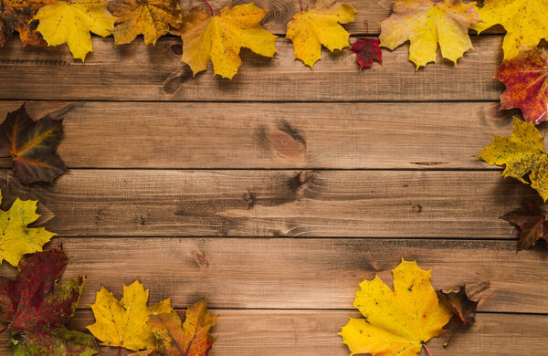 Autumn leaves frame, flat lay composition with copy space on wooden background.