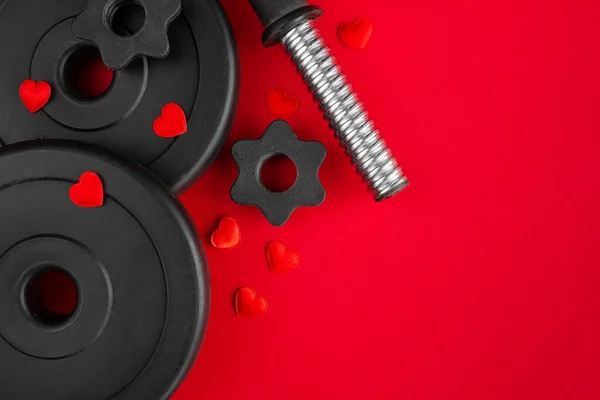 Dumbbells weight plates, decorative hearts. Love gift for Valentine\'s Day, marriage proposal engagement, birthday, anniversary, wedding. Healthy fitness gym workout composition. Flat lay copy space.