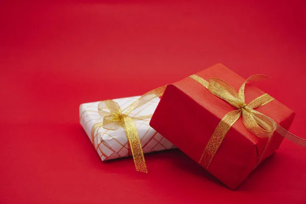 Red and white gift box with gold ribbons. Christmas gift box. Isolated on red background.