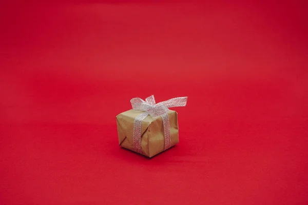 Małe Zielone Pudełko Szarą Wstążką Świąteczne Pudełko Odizolowany Czerwonym Tle — Zdjęcie stockowe