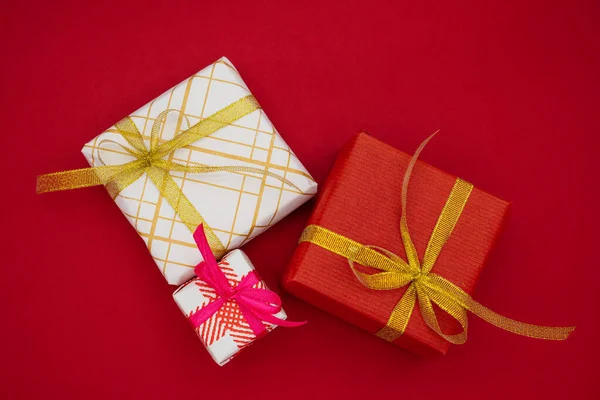 Trzy Pudełka Świąteczne Czerwonym Tle Koncepcja Bożego Narodzenia Nowego Roku — Zdjęcie stockowe