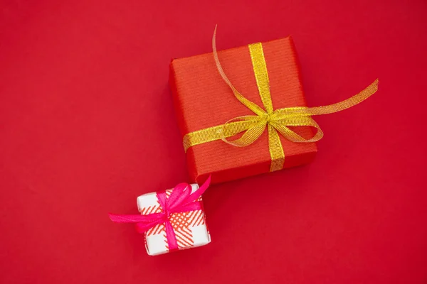 两个有弓的礼品盒红色背景的圣诞礼物 — 图库照片
