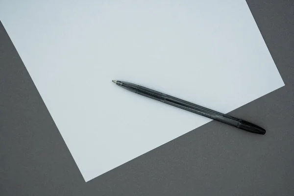 空白の白い紙と灰色の背景にペンを黒 トップ表示 — ストック写真