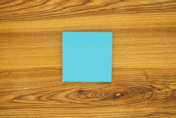 木製のテーブルの背景に青い空白の付箋 テキストのためのコピースペース — ストック写真