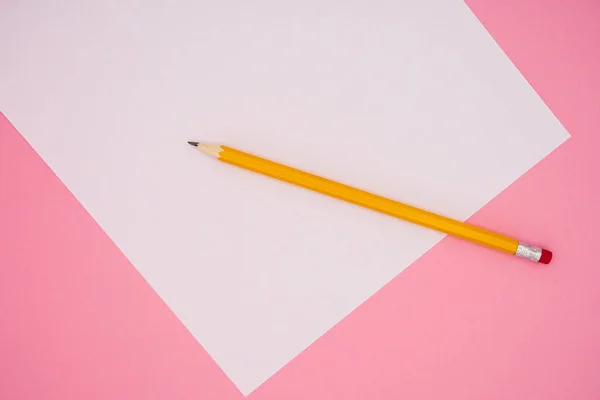 鉛筆上の白いA4紙のモックアップ ピンクの背景に テキストのためのコピースペース オフィスツール — ストック写真