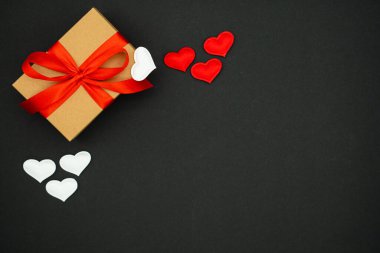 Beautiful valentines day background, with craft box with red and white hearts on black background.