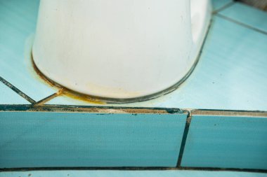 A close-up of part of a dirty toilet. Yellow stains. Unhygienic, unclean.