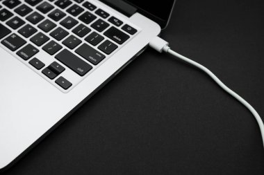 A modern laptop is standing on a black office table. Technology concept.