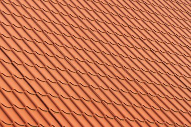 Red tiles roof. Red corrugated tile element of roof. The texture of the roof.