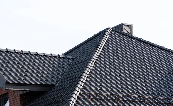 Dark brown metal roof tiles. The roof of corrugated sheet. Roof of a new home.