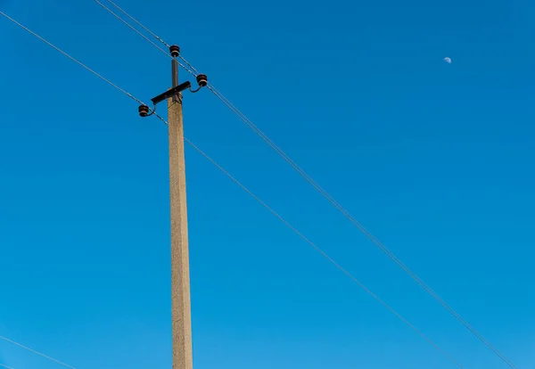 Old electric pole with wires used for electricity traffic with clear blue sky. Power electric pole.
