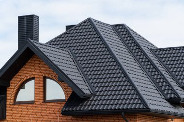 Yeni bir evin çatısı. Çelik kiremitlerle kaplı çatı. Metalden yapılmış modern çatı.