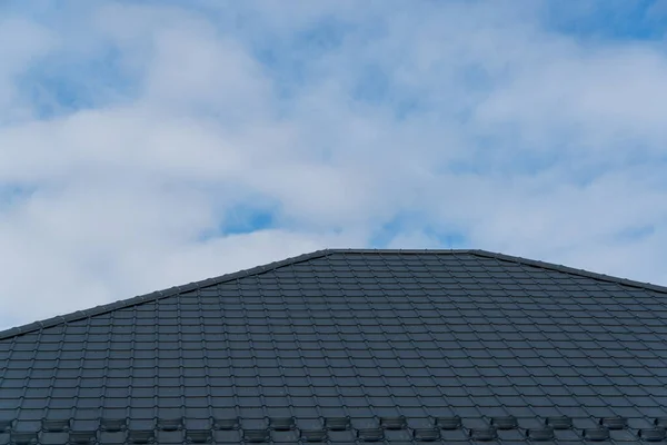 The roof is made of black metal tiles. Roof metal sheets.