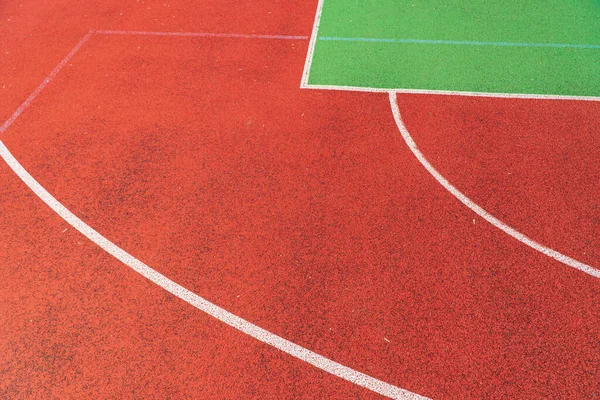 Outdoor basketball field. Detail of red outdoor basketball court.