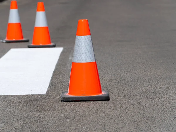 Three traffic cones on road.