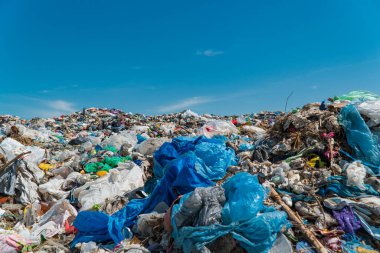 Mavi gökyüzüne karşı çöplükte bir çöp yığını. Çöp sahasında plastik hurda. Ekoloji kavramı.