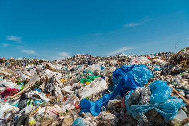 Mavi gökyüzüne karşı bir çöp yığını..