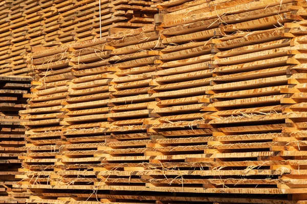 Wooden boards are stacked in a sawmill. Timber processing at the sawmill. Woodworking industry.