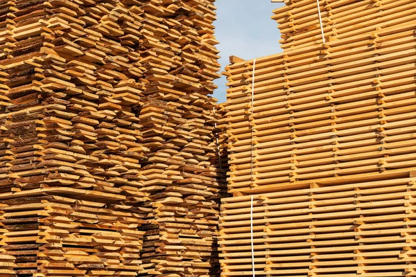 Wooden boards, lumber, industrial wood, timber. Sawing drying and marketing of wood. Piles of wooden boards in the sawmill.