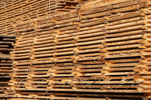 Stack of fresh pine boards in a sawmill warehouse.