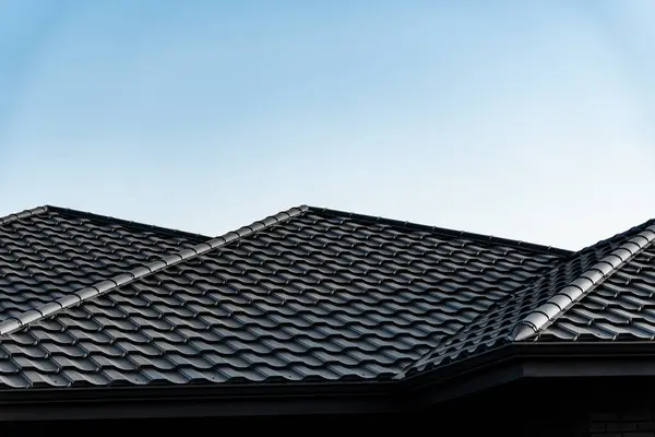 Koyu kiremitli çatı, eşsiz bir desen ve yamaçlara sahiptir. Gündüz saatlerinde banliyödeki bir evin üstündeki parlak mavi gökyüzü ile güzel bir tezat oluşturur..