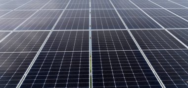 A large array of solar panels arranged in rows harnessing sunlight for sustainable energy on a sunny day, promoting eco-friendly practices in a green initiative. clipart