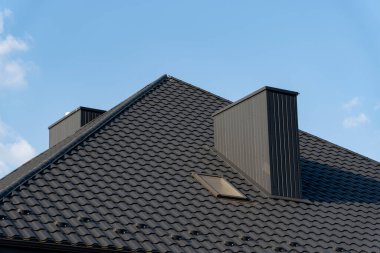 Yapı, üzerinde parlak mavi bir gökyüzü ile tezat oluşturarak çağdaş bir estetik oluşturan, iki belirgin baca ile parlak siyah kiremitli bir çatı içerir..