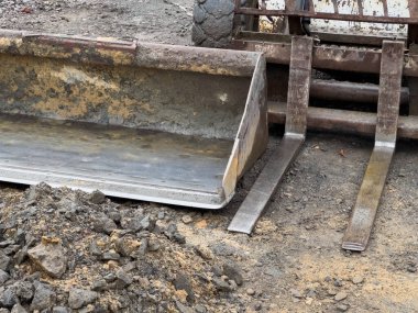 Sağlam bir vaşak kazıcısı bir inşaat alanında yer hazırlığı yapıyor. Makine toprak ve çakıl yığınlarının üzerine yerleştirilmiş, kazı görevleri için hazır..