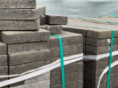 Gri tuğla kaldırımlar düzgünce istiflenmiş ve kayışlarla güvence altına alınmış. Şehir caddesinde kaldırım yapımında kullanılmaya hazır..