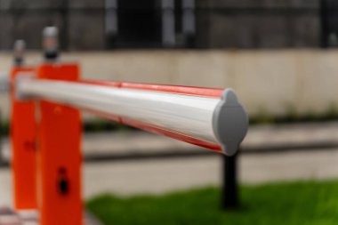 Bariyer kapısı kapalı duruyor. Sınırlı erişim sınırını işaretliyor ve güvenliği sağlıyor. Parlak renkleri ve konumu gündüz kontrollü giriş olduğunu gösteriyor.