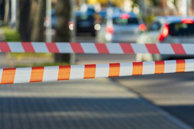 Hareketli bir şehir yolunda trafiği engelleyen canlı bir bariyer, arabalar beklenti içinde sırada beklerken, kentsel koşuşturmayı ve günlük hareketin durmasını vurguluyor.