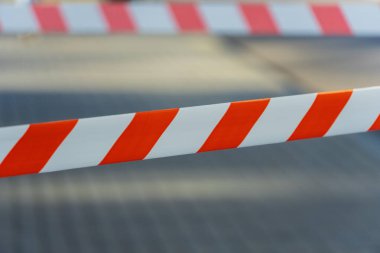 Canlı turuncu ve beyaz şeritli şeritler yol boyunca uzanıyor, kalabalık bir şehirde, yayaları dolambaçlı yoldan gitmeye teşvik eden bir inşaat alanı sinyali veriyor..