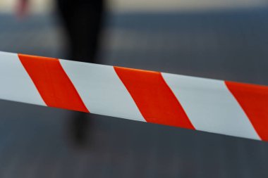 Açık renkli uyarı bandı, bulanık bir şehir geçmişine karşı belirgin bir şekilde gösterilerek, devam eden inşaat çalışmaları sırasında kamu güvenliği için bir kısıtlama alanı oluşturuluyor.