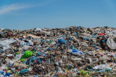 Uçsuz bucaksız bir çöp yığını açık mavi gökyüzünün altında plastik atık ve enkaz katmanları biriktirir. Çöp sahası sağlık ve ekolojik sağlık için ciddi bir sorun teşkil ediyor.