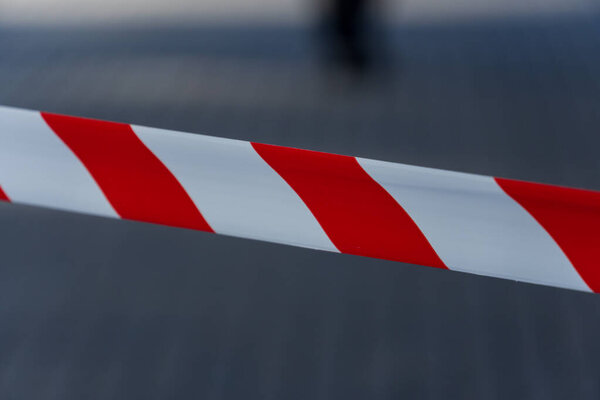 Яркая красно-белая предосторожность протягивается через городскую улицу, четко обозначая запретную зону. Этот предупреждающий знак имеет важное значение для общественной безопасности во время строительных или эксплуатационных работ.