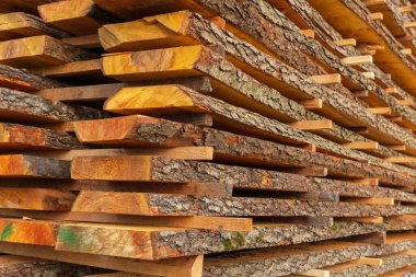 Sağlam keresteler düzenli bir şekilde istiflenir, sıcak güneş ışığıyla aydınlatılır, ahşabın eşsiz dokuları ve renkleri vurgulanır. Ayarlar kereste fabrikası ortamını yansıtıyor..