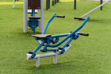 Çift egsersiz makinesi parktaki yemyeşil çimlerde oturur ve kullanıcıları açık hava fitness eğitimine davet eder. Bu ekipman sağlıklı yaşam tarzlarını destekliyor ve aktif yaşamı teşvik ediyor..
