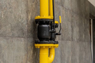 Parlak renkli sarı ve siyah doğalgaz boru hattı bağlantısı endüstriyel ortamlarda enerji taşımak için kullanılan gelişmiş teknolojiyi gösteriyor.