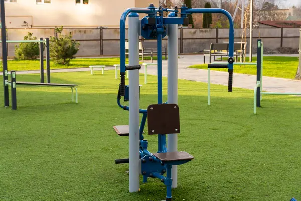 Parlak renkli spor aletleri açık hava spor salonunda kullanılmaya hazır. Çevresi yeşilliklerle çevrili bölge, bireyleri sağlık odaklı bir yaşam tarzına davet ediyor..