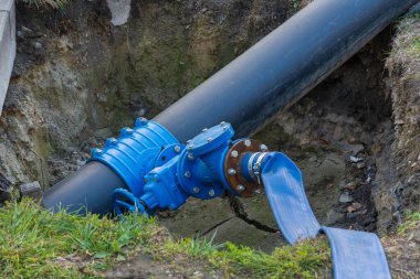 İşçiler, bir inşaat sahasında büyük bir su boru hattını onarmakla meşgul..