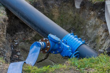 İşçiler bir inşaat sahasındaki hendeğe yerleştirilmiş büyük bir su borusunu tamir ediyorlar. Bu hayati altyapı, şehir mühendisliğinde devam eden çabaları gözler önüne sererek su kaynaklarını destekliyor..