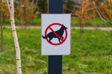 Parktaki uyarı işareti açıkça köpeklerin evcil hayvan kurallarına uymalarını yasaklıyor..