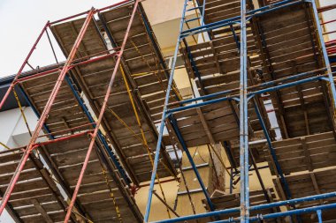 İşçiler, devam etmekte olan bir inşaat alanındaki inşaat projelerini güvenli bir şekilde yönetmek ve tamamlamak için sağlam iskeleye güveniyorlar.