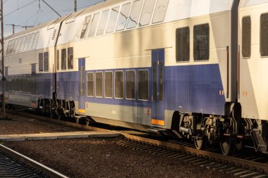 Şık bir elektrikli tren, çağdaş demiryolu tasarımı ve verimli ulaşım sergilenen hareketli bir istasyonda platforma yaklaşıyor..