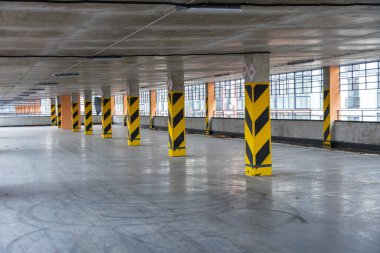 Geniş bir yeraltı otoparkı. Yapısal sütunları ve doğal ışık için geniş pencereleri olan işaretli yerleri gösteriyor..