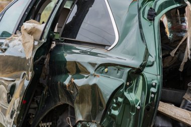 Şiddetli bir kazaya karışan yeşil bir araba, trafik kazalarının tehlikelerini vurguluyor..