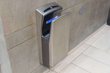 Son teknoloji el kurutma ekipmanları şık bir banyoya monte edilir, kullanıcılar için hijyen ve modern kolaylığı teşvik eder.