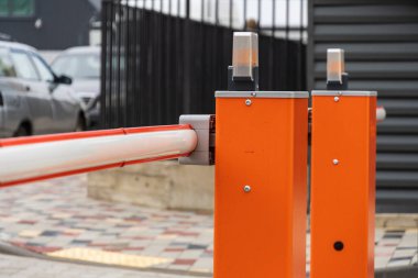 Otomatik bariyer kapısı kapalı duruyor, iyi organize edilmiş bir otoparka girişi kontrol ediyor, araçların güvenliğini ve güvenliğini sağlıyor..